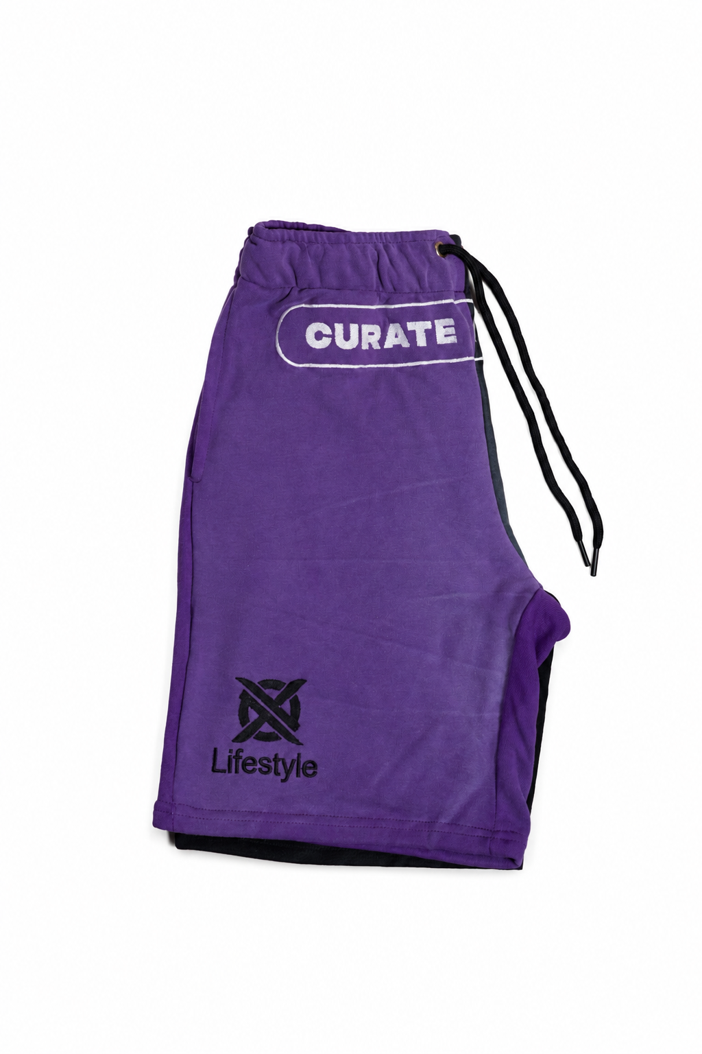 Purple athletic shorts with a black drawstring, featuring a white 'CURATE' logo on the upper right hip and a black 'Lifestyle' logo on the lower left hip, shown against a plain white background.