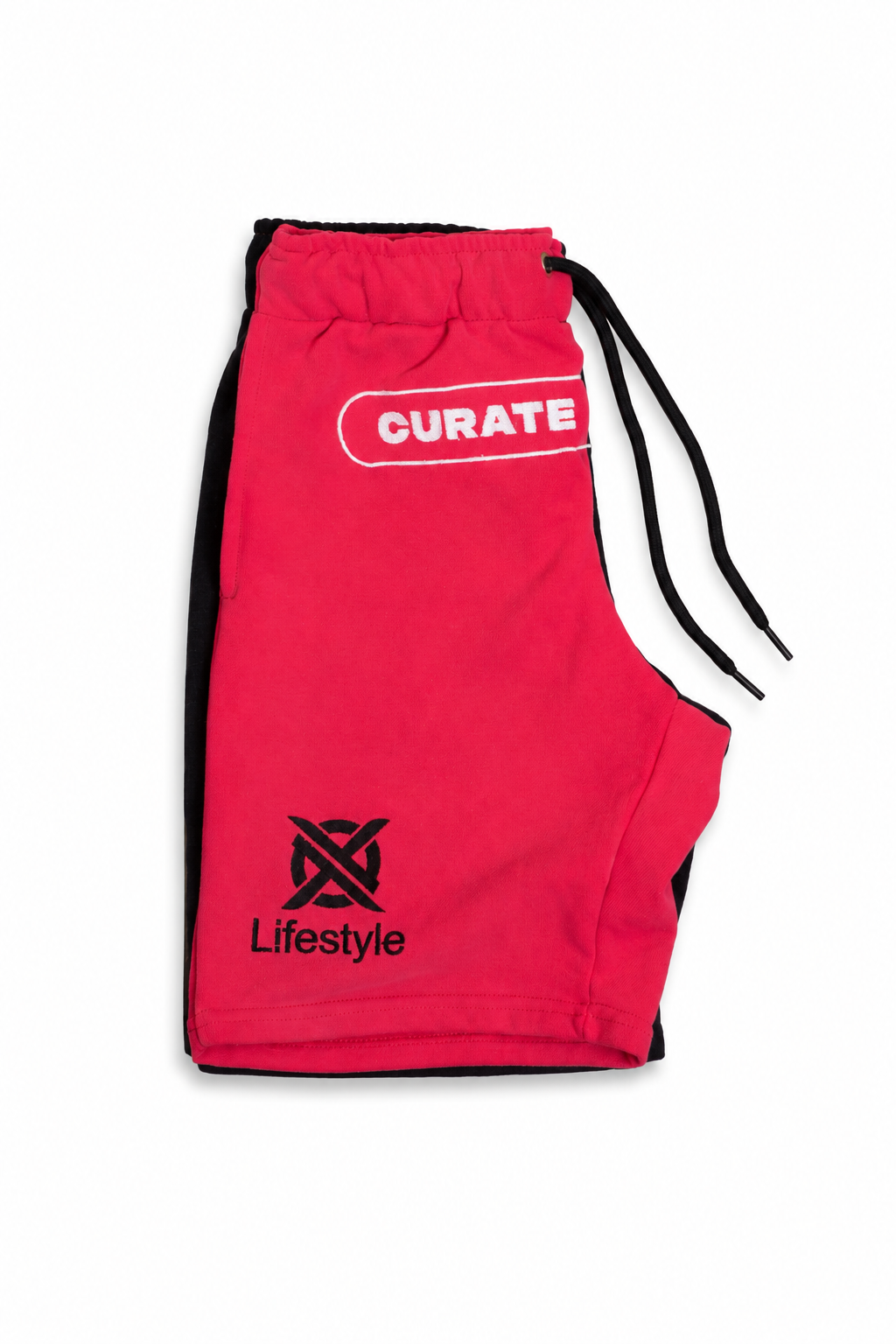 Bright pink athletic shorts with black side panels, a black drawstring, a white 'CURATE' logo on the upper right hip, and a black 'Lifestyle' logo with a stylized 'X' on the lower left hip, shown on a plain white background.